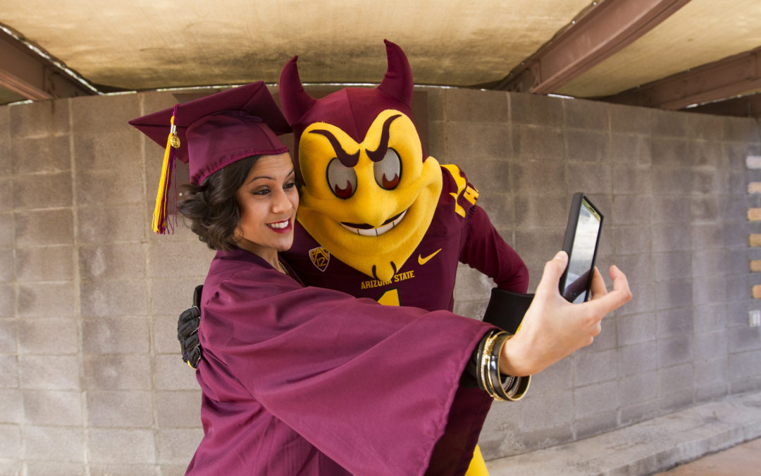 A woman poses with Sparky at the fall 2014 Ira A. Fulton Schools of Engineering Convocation check-in