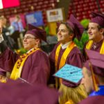 Three graduates wave to someone at the Fulton Schools Convocation