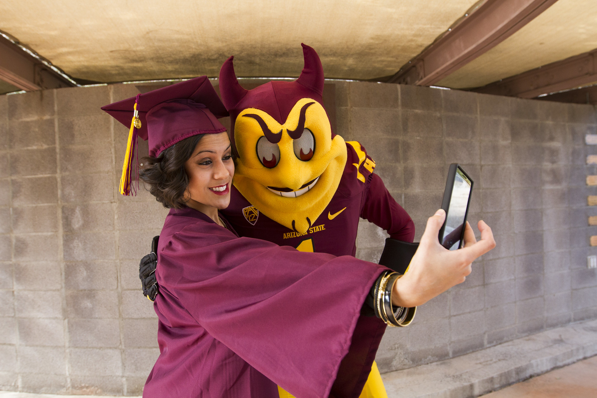 A woman poses with Sparky at the fall 2014 Ira A. Fulton Schools of Engineering Convocation check-in