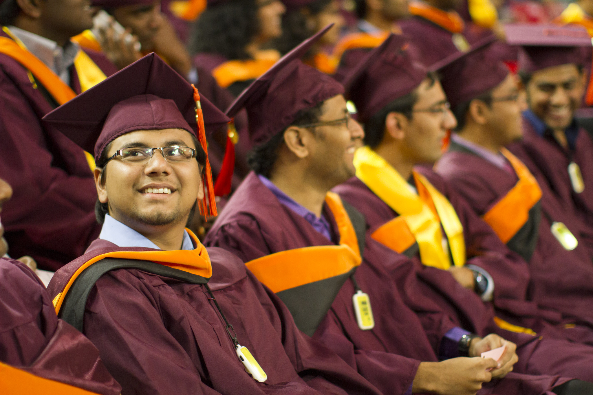 A graduate looks up and smiles as he awaits the convocation ceremony to begin