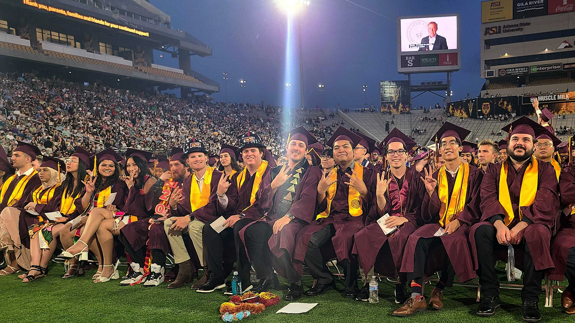 The graduates of the class of 2024 sit, smiling and joyful, on the field at Arizona State University's Mountain America Stadium as the Ira A. Fulton Schools of Engineering Convocation begins.