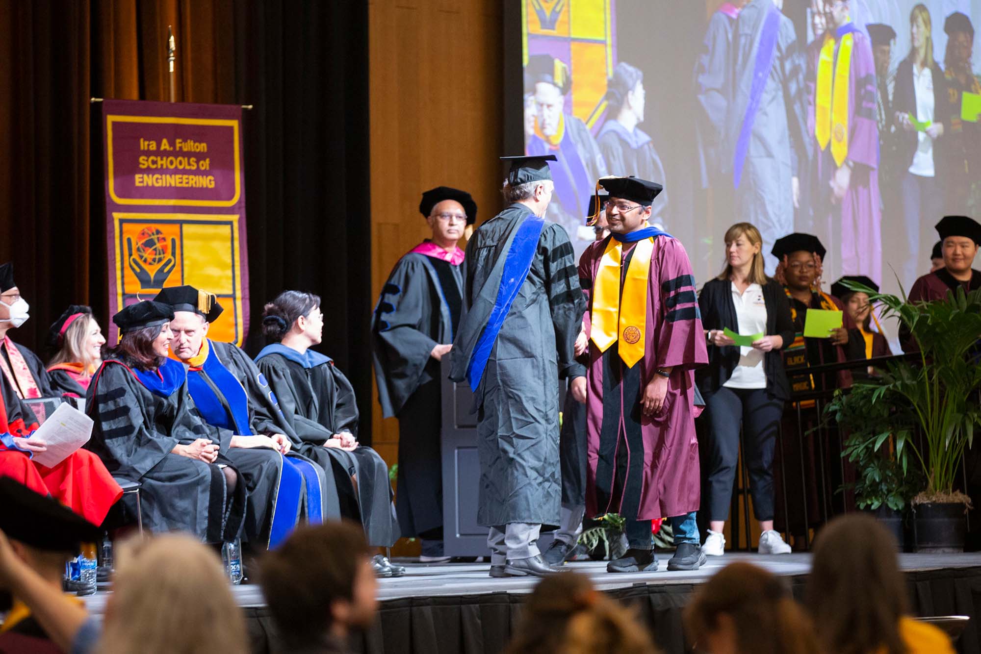 A student shakes hands with his advisor after being hooded at the Fall 2022 Fulton Schools PhD Ceremony