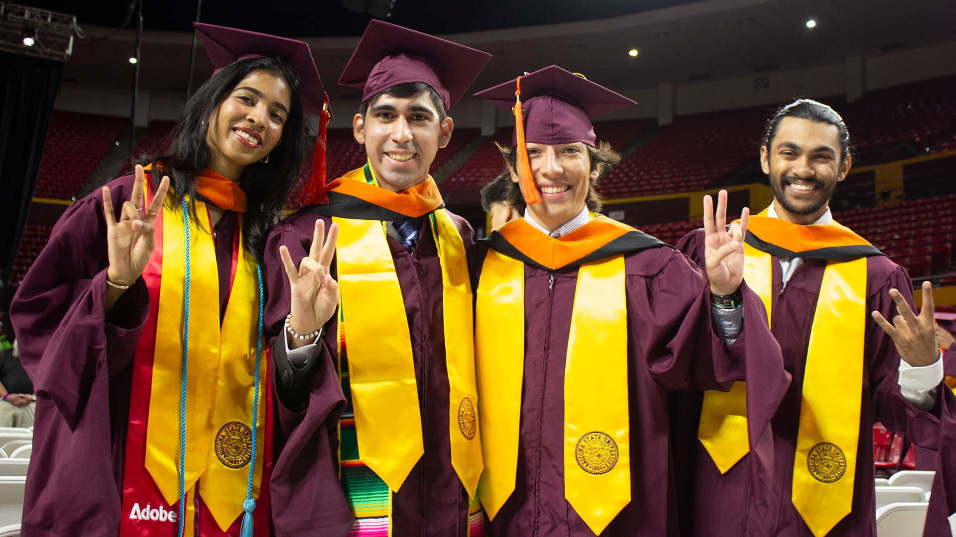 Four ASU Engineering graduate students stand together in their ASU regalia at the Spring 2025 Maroon Graduate Convocation.