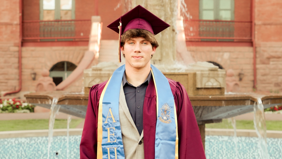 Portrait of Jacob Gimbel in his graduation regalia in front of the ASU Old Main fountain